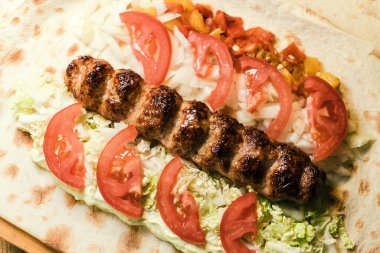 Köfteli Shawarma, soslu, domatesli, biberli, peynirli, otlu, lahanalı, soğanlı ve sarımsaklı.