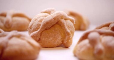 Geleneksel Meksika Günü 'nde, arka planda ölü ekmeklerin olduğu bir kamera ve bir parça ekmek alan bir kişi..