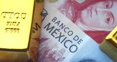 Mexican currency with gold bars around.