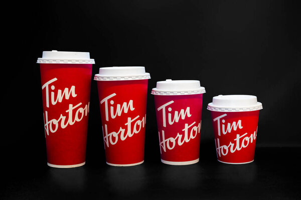 Calgary, Alberta, Canada. April 9, 2022. Tim Hortons coffee cups of different sizes on a black background