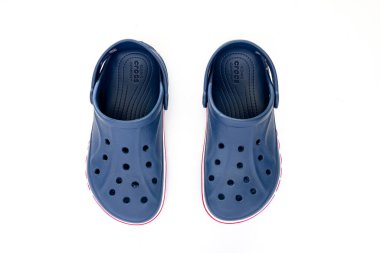 Calgary, Alberta, Kanada. 30 Nisan 2022. Beyaz masadaki mavi Crocs sandaletlerinin üst görüntüsü..