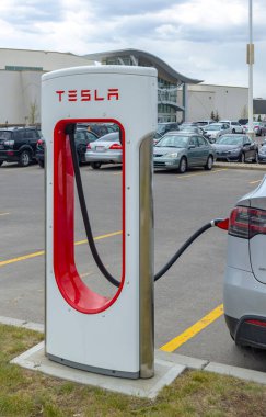 Calgary, Alberta, Kanada. Haziran 2022. Elektrikli arabayı şarj eden bir Tesla Supercharger standının dikey görüntüsü.