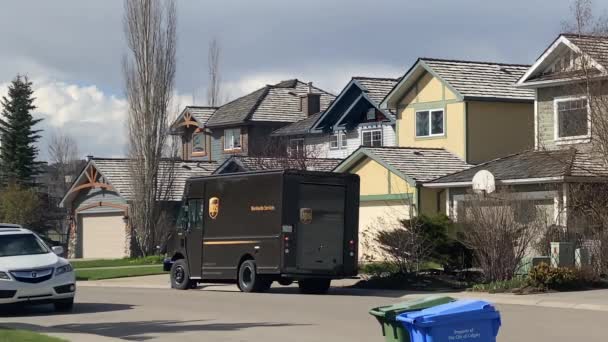 加拿大艾伯塔省卡尔加里 2022年5月22日 一个Ups卡车停在房子前面 一个送货人拿着一个包裹 — 图库视频影像