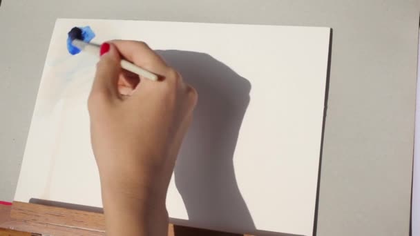 Kunstenaar meisje swatching ultramarijn blauw met behulp van ezel — Stockvideo