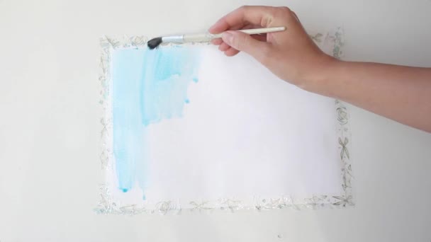 Meisje dat wit papier bedekt met cerulean blauwe verf — Stockvideo