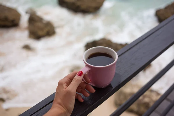 Дівчина насолоджується ранковою кавою в штормовий день на морі — стокове фото