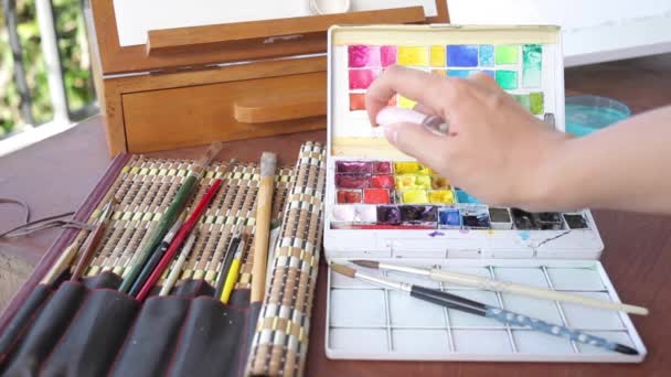 Artista rociando agua sobre sartenes de pintura de acuarela conjunto — Vídeos de Stock