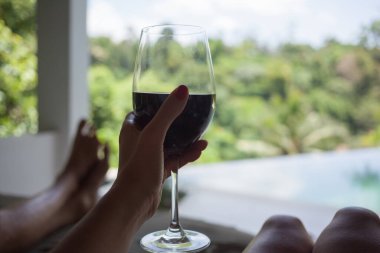 Yeşil bahçedeki havuz kenarında bir bardak şarap. Tarih.