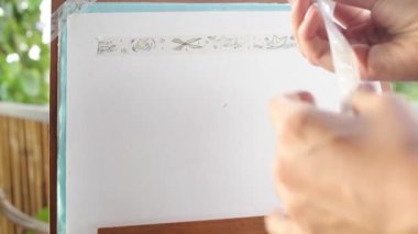 Havadaki kız kağıda washi bandı yapıştırıyor.
