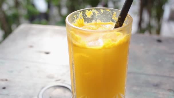 Θηλυκό χέρι ανακατεύοντας φρέσκο χυμό πορτοκαλιού σε εξωτερικούς χώρους — Αρχείο Βίντεο