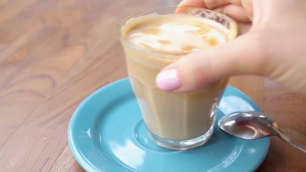 Flicka dricker kaffe latte. Njut av ett café utanför — Stockvideo