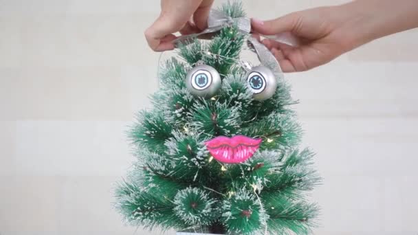 Niña atando lazo de cinta de plata en el árbol de Navidad — Vídeo de stock