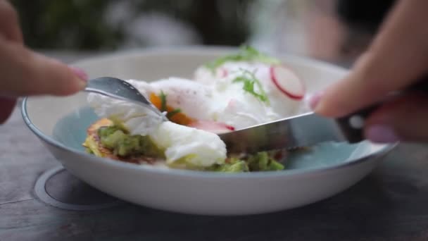 Cutting poached eggs with radish on bread toast — Stock Video