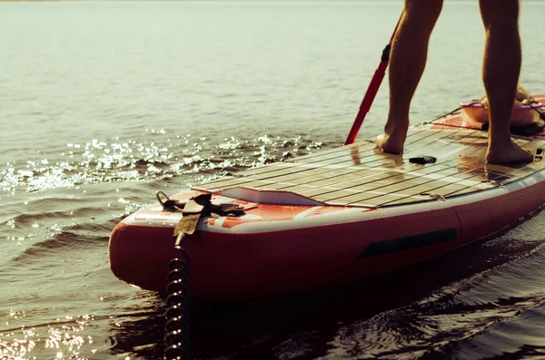 Мужской гребля на SUP доске на озере крупным планом — стоковое фото