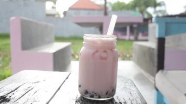 Pembe boba karıştıran kız. Açık havada yaz içkisi.