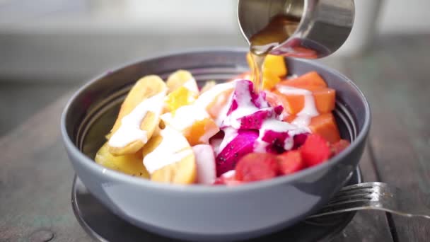Mână poruing miere pe salată de fructe tropicale mixte — Videoclip de stoc