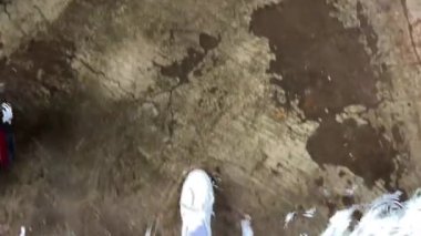 POV beyaz spor ayakkabıları yağmurlu su birikintilerinde yürüyor