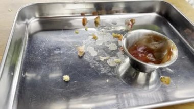 Hamburger ve ketçap kalıntılarıyla dolu boş metal tepsi