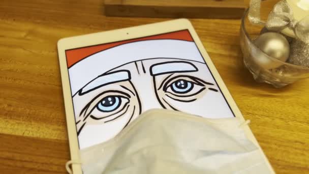 Kafedeki tablet sesesinde tıbbi maske takan Noel Baba. — Stok video