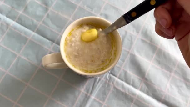 Mélanger le beurre dans une tasse de bouillie d'avoine chaude 4k — Video