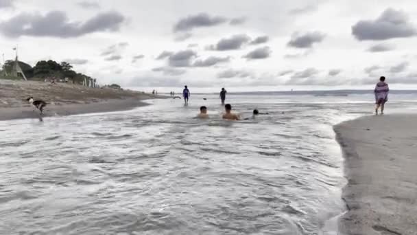 Bali, Indonesia - 20 de noviembre de 2021: personas bañándose en el río que desemboca en el océano — Vídeo de stock