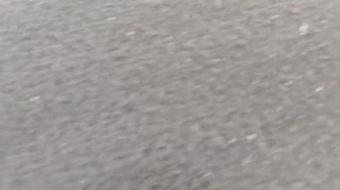 Bali 'de siyah volkanik kumu yıkayan beyaz deniz köpüğü.