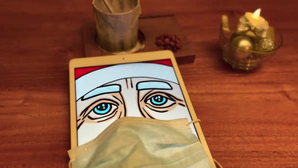 Weihnachtsmann mit medizinischer Maske auf Tablette im Café — Stockvideo