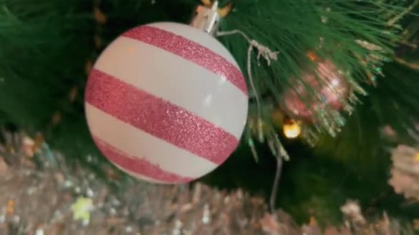 Hermosas bolas de color rosa en abeto verde con luces de Navidad y guirnalda de plata en el interior. 4k pino festivo para Nuevo. Imágenes de grano de película — Vídeos de Stock