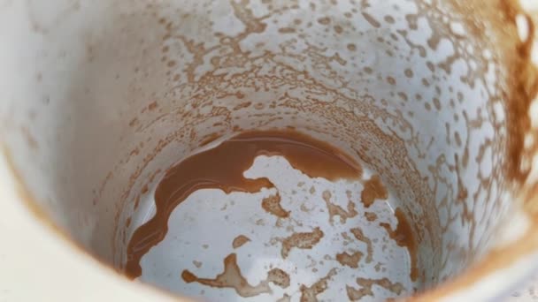 Fortunetelling med kaffe kvarlevor. Tomma vita kopp latte. Smaklig cappuccino mönster på nära håll. — Stockvideo