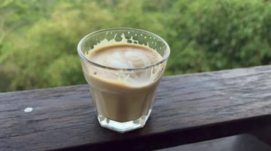 Batur 'a bakan teras demiryolunda sıcak latte camı. Seyahat Bali. Kintamani 'de Batur Gölü' nün kıyısında muhteşem dağ manzaralı bir kahve.. 