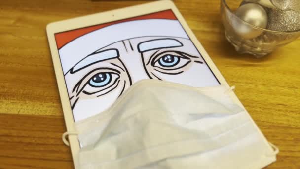 Triste Santa indossando maschera medica sul tablet sceen al caffè poi svanire nella disperazione. — Video Stock