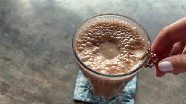 Vrouw die kerstlepel decor aanraakt in een glas latte koffie. Kerstmorgen met cafeïnedrank. — Stockvideo