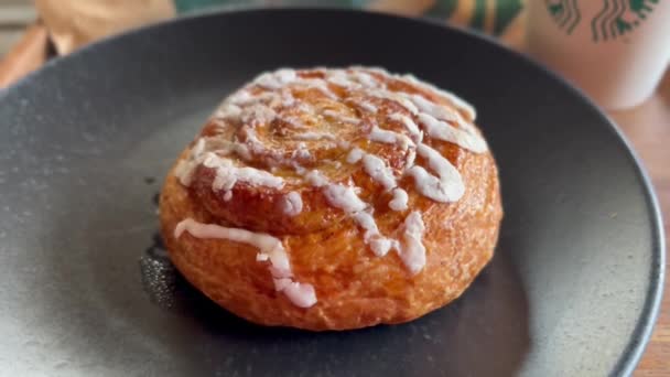 Bali, Indonesia - December, 7, 2021: Close up of cinnamon bun on a tray with coffee cup at Starbucks cafe. — Stockvideo