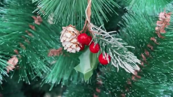 Hermoso cono de abeto y bayas rojas. Decoración del árbol de Navidad en estilo vintage natural de cerca. — Vídeos de Stock