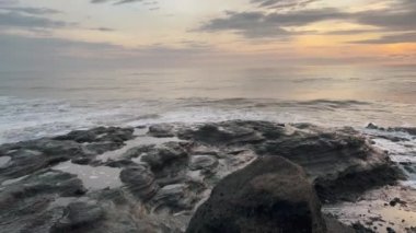 Okyanus kıyısındaki Ricks 'e su sıçrıyor. Deniz dalgaları ve gün batımının ışıltısıyla altın saat.