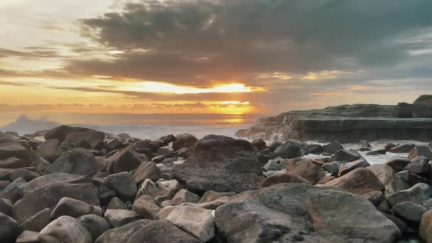Gün batımında okyanus dalgaları kayalara çarpıyor. Altın saatte Bali alacakaranlığı. — Stok video