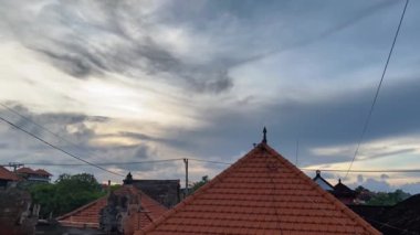 Gün batımında gökyüzünde kara bulutların zaman akışı. Kerobokan bölgesindeki yerel köyde Bali altın saati