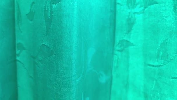 Zöldszövet sodródik a szélben. Smaragdzöld függöny virágos mintával, mint a tervezés háttere. — Stock videók