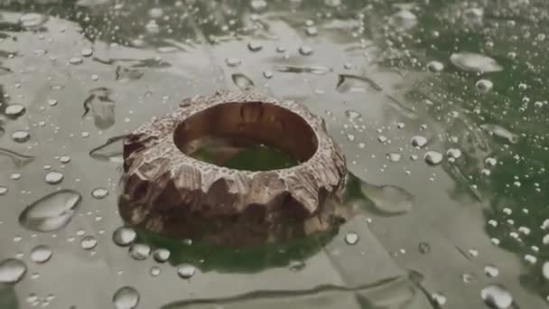 Silver ring moving with rain drops outdoors — Stock video