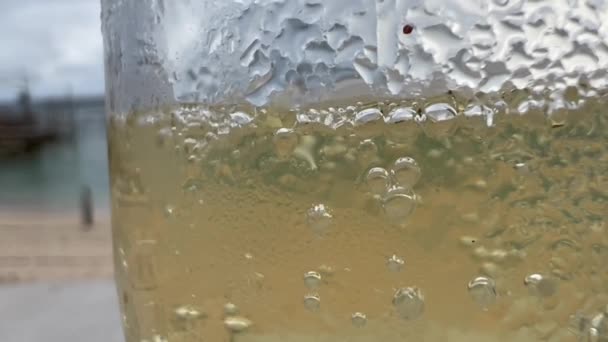 Close up macro texture of dew drops and bubbles in a champaign glass on seaside at port — стоковое видео