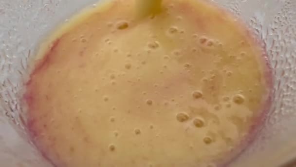 Крупним планом макро текстура густого манго і грейпфрутового соку з бульбашками в склянці. Перемішувати здоровий літній напій і просіювати соломинку . — стокове відео