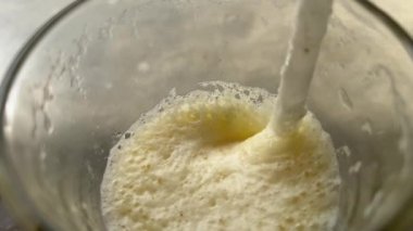 Yakın plan, taze sıkılmış tropik meyve suyu içiyor. Ananas ve portakallı kokteyl makro görüntüleri.. 