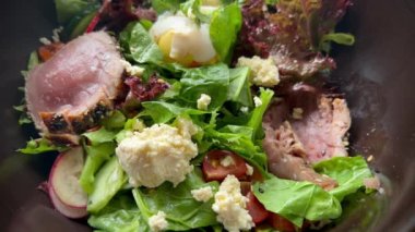 Çiğ ton balıklı sashimi ve peynirli sağlıklı salata yemek. Deniz ürünleri aşığı için sebze kasesi. Öğle yemeği için makro doz protein. Pov balık ve yumurtalı taze salata yiyor..