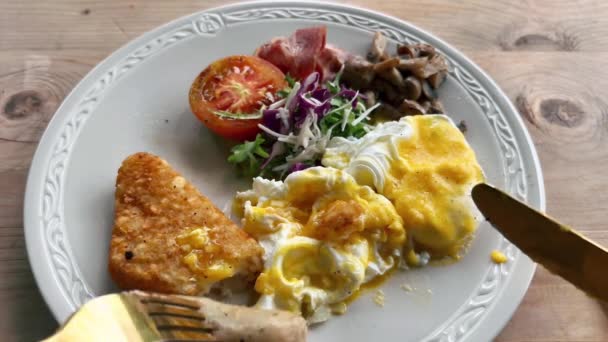 Krájení klobásy na velký snídaňový talíř zeleniny s omeletou a hashbrown. — Stock video