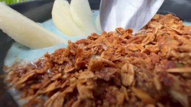 Armut dilimleri ve granola ile nefis mavi smoothie kasesi. Lezzetli sağlıklı kahvaltı görüntülerinin makro yakın çekim görüntüleri. Meyve püresi ve fırında yulaf yemek..