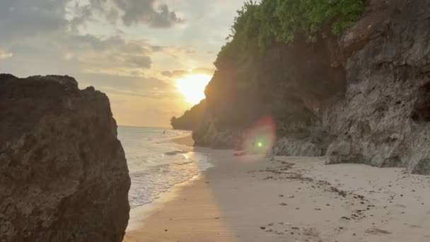 Vista POV riprese in diretta della telecamera di camminare lungo la riva dell'oceano con scogliere di sabbia bianca al tramonto. Vista in prima persona del lungomare al tramonto nel paradiso tropicale. Viaggi Isola di Bali. — Video Stock