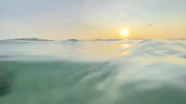 Hint Okyanusu kıyısının su altı görüntüleri çok güzel. Altın güneş altın saatinde suyun içinden parlıyor. Yeşil denizde banyo yapan POV canlı kamera görüntüsü.