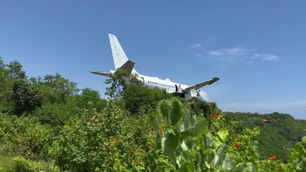 海岸近くの高い崖の上に白い放棄された飛行機の美しいライブカメラ映像。バリ島の南陽ビーチで壊れた航空機. — ストック動画