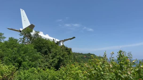 Statické záběry rozbitého opuštěného letadla v divočině na útesu u moře. Projekt hotelu uvnitř starého letadla na ostrově Bali na Nyang Nyang Beach. — Stock video