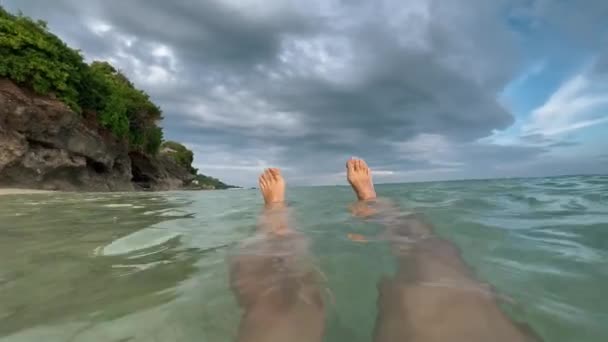 Point de vue de la femme se baignant dans l'eau bleue de l'océan à la plage tropicale sauvage en Indonésie. Fille à la peau blanche nageant dans la mer. — Video